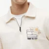 Polo-tröja med blommig logotyp och kvartslång dragkedja Polo-tröja med blommig logotyp och kvartslång dragkedja
